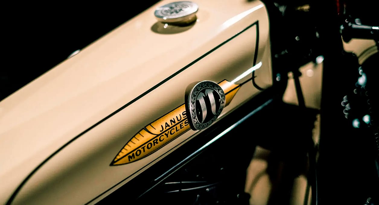 Close-up of the Janus Motorcycles badge on a cream hand-painted fuel tank