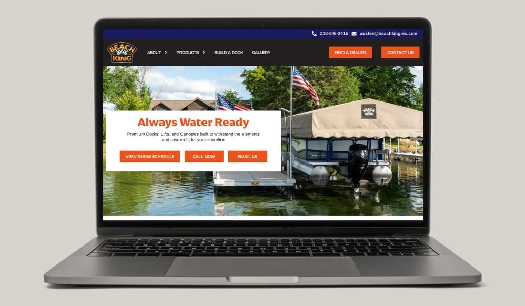 Beach King website on a laptop, headlined Always Water Ready over a lakeside dock and boat lift