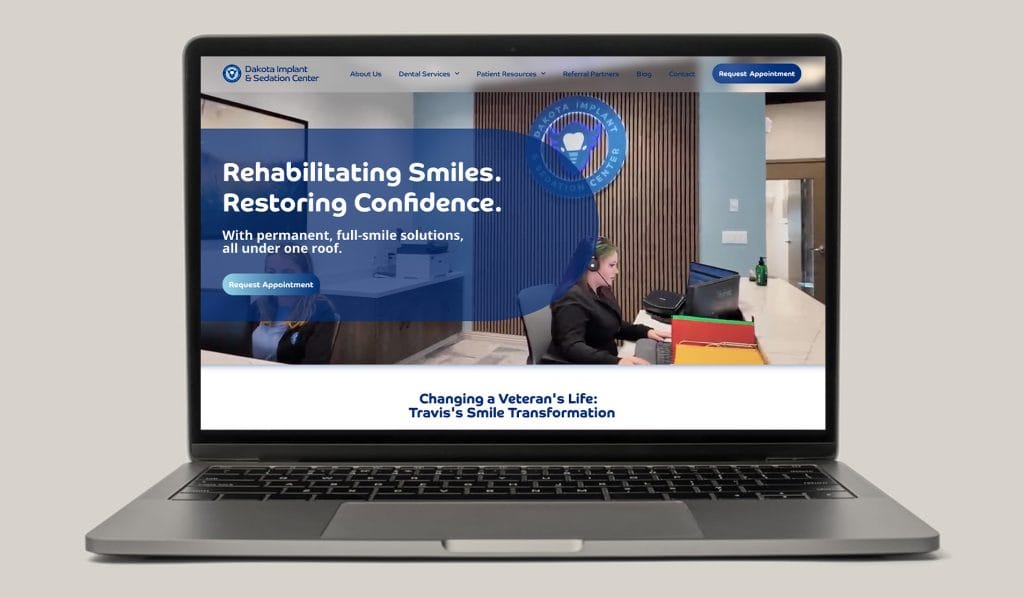 Dakota Implant & Sedation Center website on a laptop, headlined Rehabilitating Smiles, Restoring Confidence